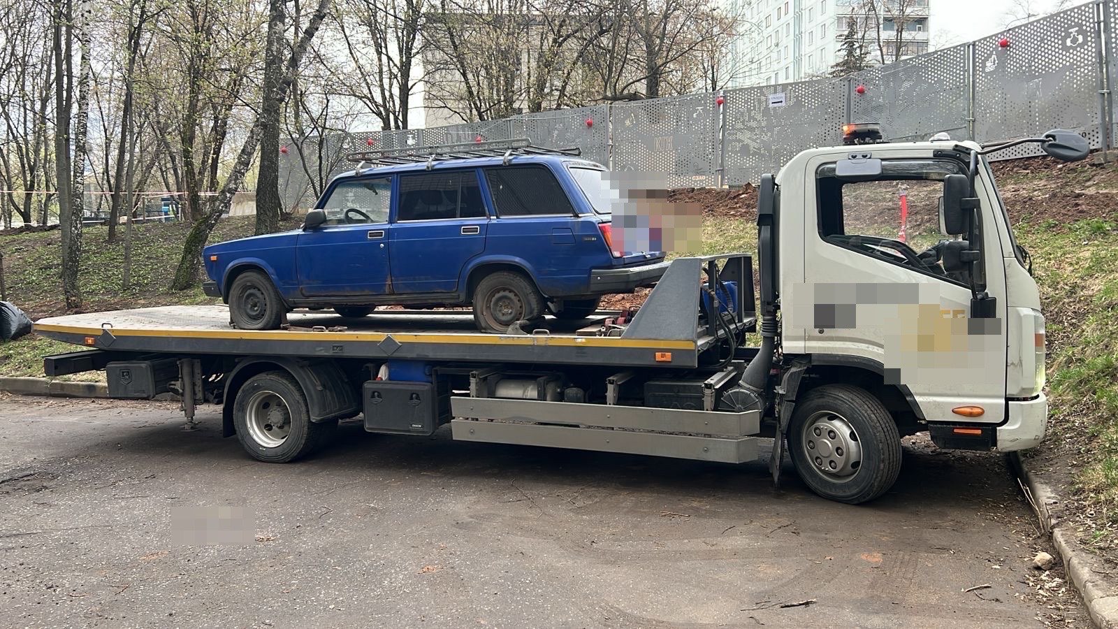 Погрузка автомобиля во дворе на платформу